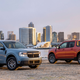 A photo of two Ford Maverick pickups parked with a city behind them.